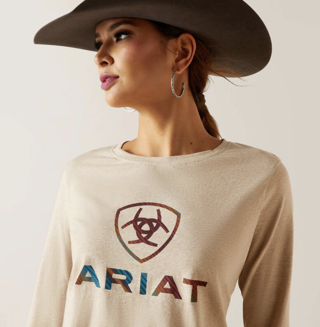 woman wearing cream shirt that says ariat and a brown cowboy hat